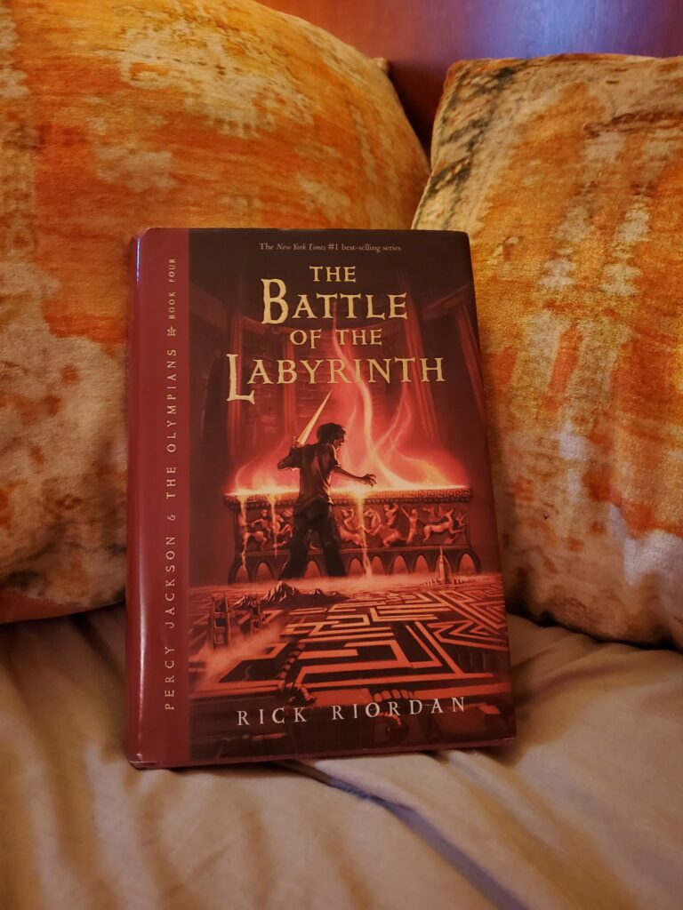 A copy of the book 'The Battle of the Labyrinth' resting on a pile of pillows